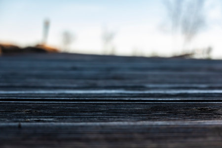 Detail view of a wooden walkway by a lake on a beach with blurred surroundingsの写真素材