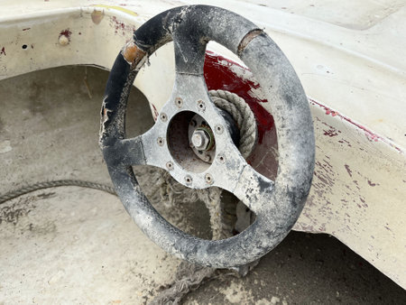 Wreck of a wrecked small motorboat with a steering wheelの写真素材