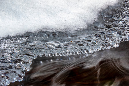 Beautiful icicle formations during the freezing of the stream in winter