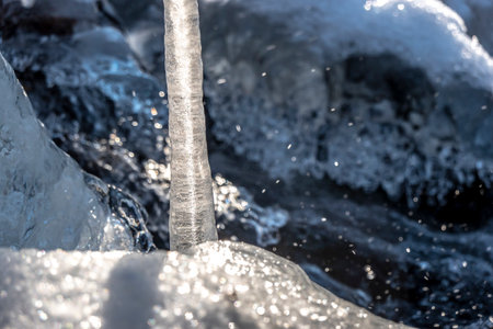 Beautiful icicle formations during the freezing of the stream in winterの写真素材