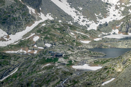 The cold valley of the five SpiÅ¡ Lakes with a mountain hut, view from Lomnicke saddle High Tatras Slovakiaの写真素材