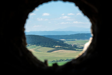 A view of the surroundings through an opening in the castle wall of the castle ruins