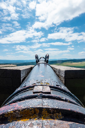 A historical cannon at the Spis castle in Slovakia symbolically aimed behind the walls to defend itの写真素材