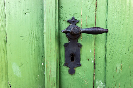 Ancient metal handle with a lock on a wooden doorの写真素材