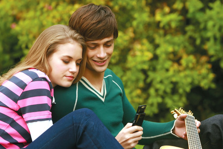 Romantic young couple relaxing outdoors in park smiling の写真素材