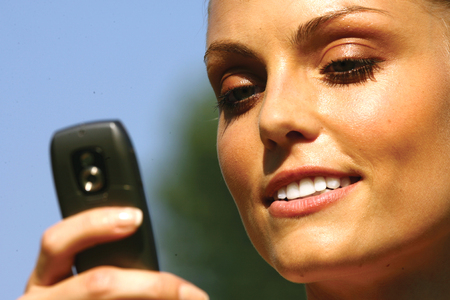 Beautiful woman talking on cell phone while looking at copyspace の写真素材