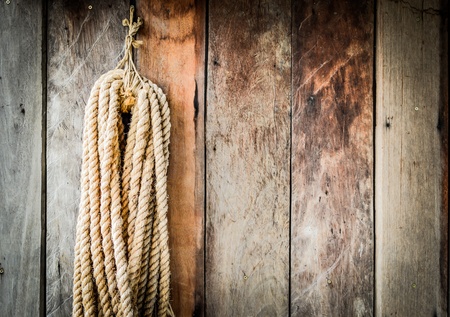 Old wooden board with a hanging rope.の写真素材
