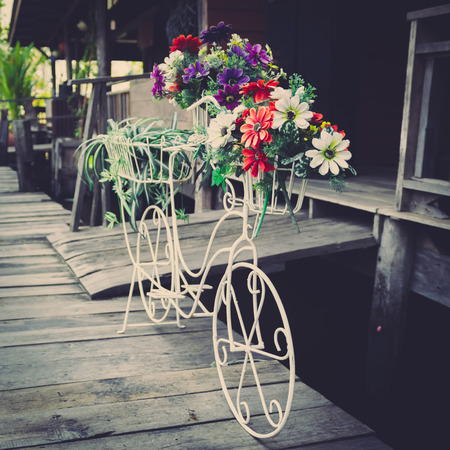 Vintage photo of white bicycles with flowers in antique old houseの写真素材