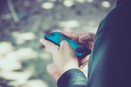 Woman using her Mobile Phone.on the beach Background.