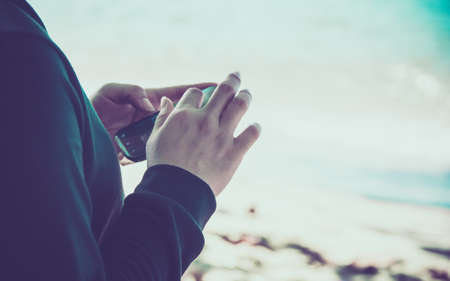 Woman using her Mobile Phone.on the beach Background.の写真素材