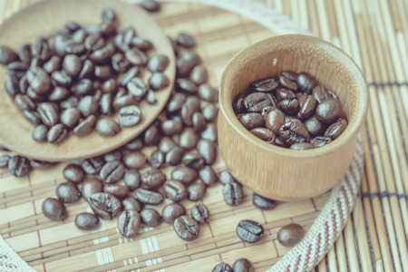 Coffee beans and coffee cup set on bamboo wooden background.Photo in retro color image style, Soft focus.の写真素材