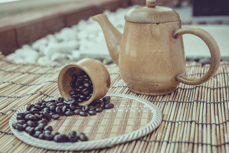 Coffee beans and coffee cup set on bamboo wooden background.Photo in retro color image style, Soft...