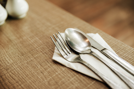 fork, spoon and knife with white paper on the old wood table For breakfast.の写真素材