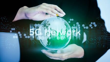 5G network internet mobile wireless business concept. Multiple exposures of Businesswomen holding wold globe for new generation networks and high-speed mobile Internet.の写真素材