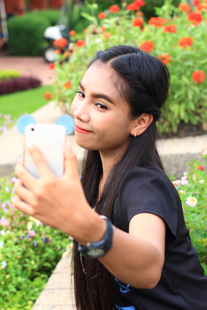woman taking picture of herself in parkの写真素材