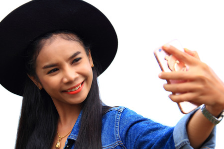 woman taking picture of herself on white backgroundの写真素材