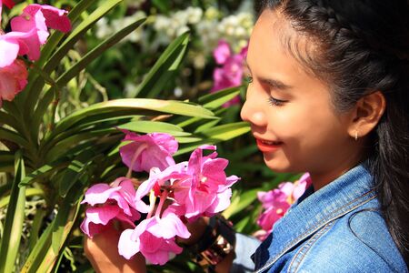 woman smelling orchid flowers in the gardenの写真素材