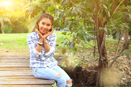 woman cheerful sitting on wood bridge in gardenの写真素材