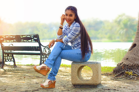 woman sitting relaxing on chair happiness beside the pond in garden の写真素材