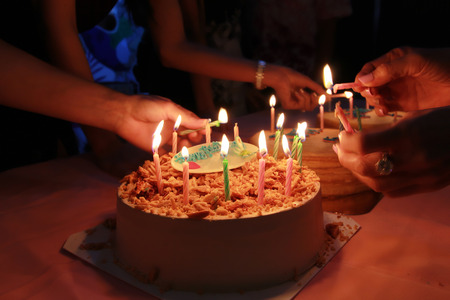 birthday cake with celebration party,Happy birthday to your friends are fun,close up hand and light the candleの写真素材