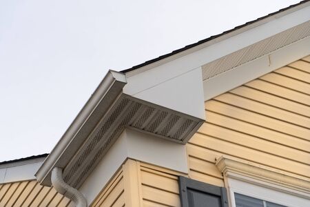 Horizontal vinyl siding, white frame gutter guard system, fascia, drip edge, soffit, on a pitched...