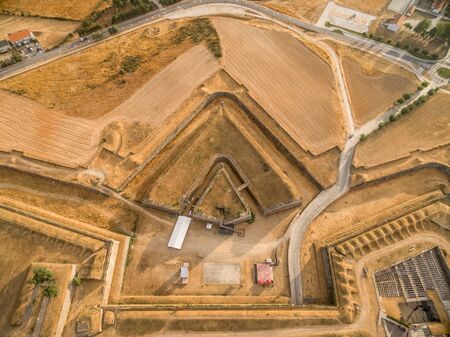 Elements of a fortification: aerial view of a triangle shape ravelin or demi lune with a redoubt in the ditch between 2 bastions in Almeida Portugal, structure adds additional defense to the gateの写真素材