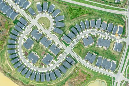 Aerial view of the geometrical curving American residential neighborhood, single family homes built close to each other by a cross street in Two Rivers Crofton Maryland United Statesの写真素材