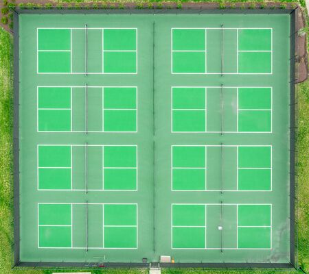 Aerial top down view of a group of tennis courts with  green pavement, baseline, singles' sideline, doubles' sideline, net, net posts, center mark, service line, doubles alley,の写真素材
