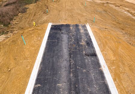 Unfinished asphalt covered road in a new American residential neighborhood in Marylandの写真素材