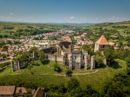 Aerial view of ruined medieval Slimnic castle with donjon, ruined Gothic church, gate tower and barbican in Transylvania Romaniaの写真素材