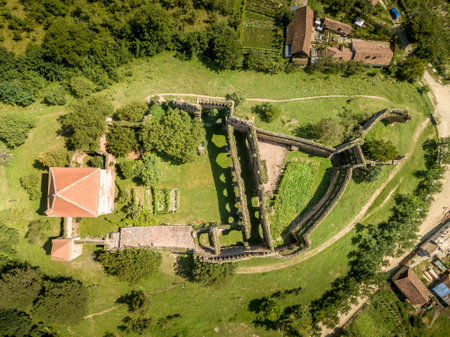 Aerial view of ruined medieval Slimnic castle with donjon, ruined Gothic church, gate tower and barbican in Transylvania Romaniaの写真素材