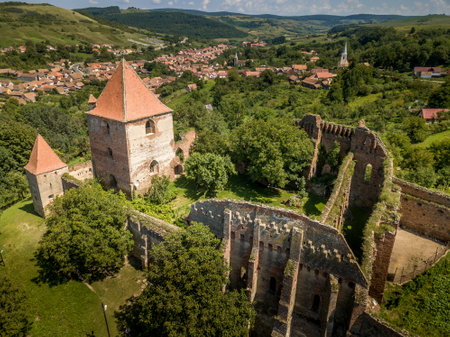 Aerial view of ruined medieval Slimnic castle with donjon, ruined Gothic church, gate tower and barbican in Transylvania Romaniaの写真素材
