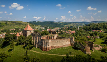 Aerial view of ruined medieval Slimnic castle with donjon, ruined Gothic church, gate tower and barbican in Transylvania Romaniaの写真素材