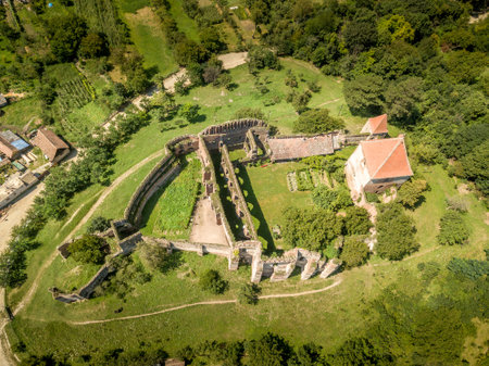 Aerial view of ruined medieval Slimnic castle with donjon, ruined Gothic church, gate tower and barbican in Transylvania Romaniaの写真素材