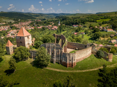 Aerial view of ruined medieval Slimnic castle with donjon, ruined Gothic church, gate tower and barbican in Transylvania Romaniaの写真素材