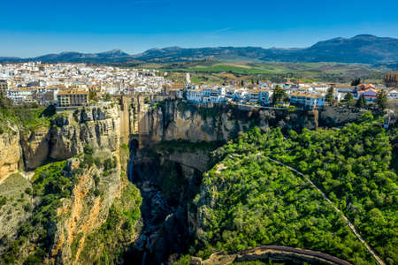 Ronda Spain aerial view of medieval hilltop town surrounded by walls and towers with famous bridge over gorgeの写真素材