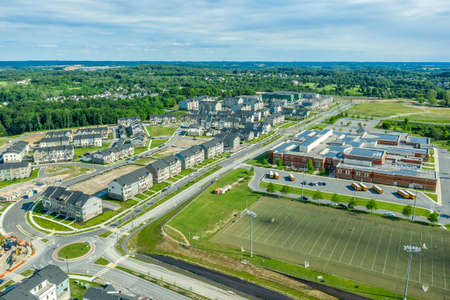 Aerial view of new middle class residential community with multifamily unit apartments, condos with balconies, duplexes, town homes and single family homes neighborhood Maryland USAの写真素材