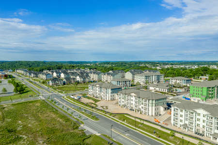 Aerial view of new middle class residential community with multifamily unit apartments, condos with balconies, duplexes, town homes and single family homes neighborhood Maryland USAの写真素材
