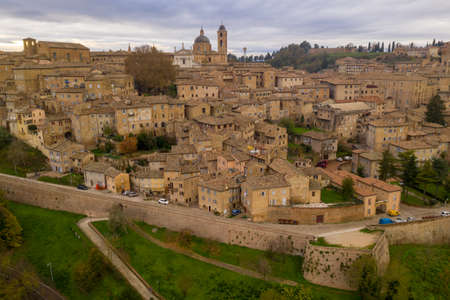 Aerial view of the Ducal Palace of Urbino medieval walled town and university in Marche, Italy with blue sky, popular travel destinationのeditorial素材