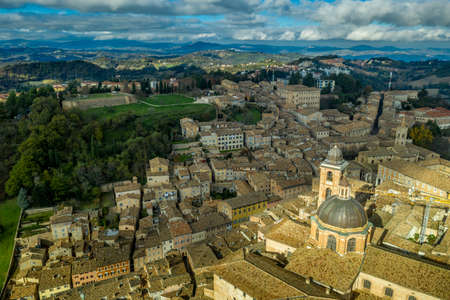 Aerial view of the Ducal Palace of Urbino medieval walled town and university in Marche, Italy with blue sky, popular travel destinationのeditorial素材