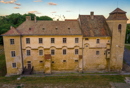 Dramatic colorful sky over Mosonmagyarovar castle and church at sunsetのeditorial素材