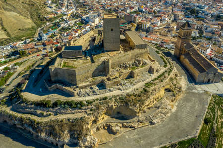 Aerial view of medieval Alcaudete castle in Andalusia Spain with donjon, high stone walls and loopholes next to the town churchのeditorial素材