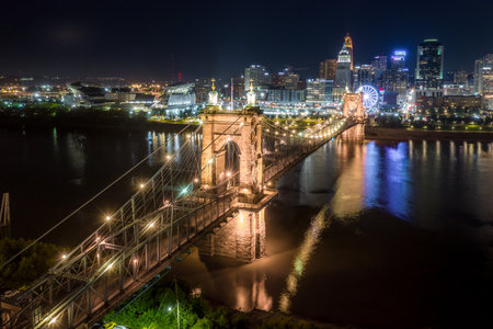 Panoramic night view of Cincinnati downtown with the historic Roebling suspension bridge over the Ohio riverのeditorial素材