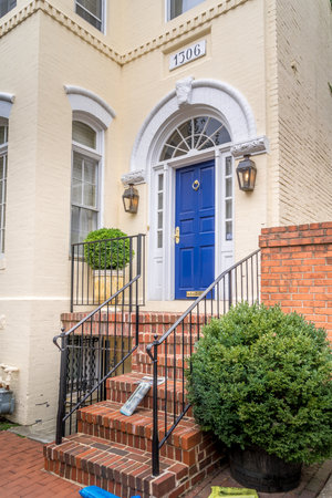 Georgian colonial style luxury house with white windows and yellow brick facade blue door in Georgetown Washington DC USAのeditorial素材