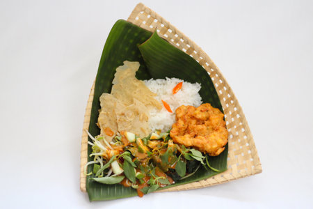 Rice with Shrimp and fried shrimp in a banana leaf basket on white background, Pecel riceの写真素材