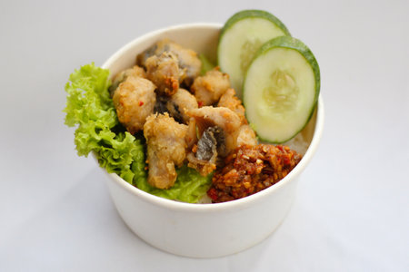 A bowl of food with Bandeng fish, vegetable, and, cucumber slice on topの写真素材