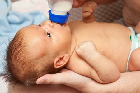 baby sucks from a bottle, close-up