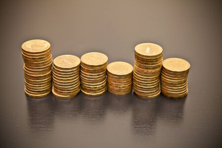 stack of coins on a black wooden background