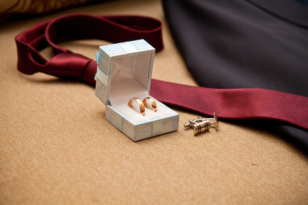 wedding rings, cufflinks tie on the couch