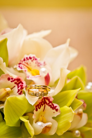 Wedding rings on a bouquet of orchidsの写真素材
